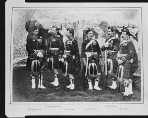 Photograph of soldiers from the Seaforth Highlanders who served in the Anglo-Egyptian War. Standing in an informal line from left to right are Sergeant Major Alexander Salmond, Colour Sergeant William McDonald, Colour Sergeant William Coxe, Private Michael McMahon, Private Richard McAnary and Private Patrick Gillon. All are wearing Highland military uniform including kilts and sporrans and most are holding a rifle. There is a rocky ledge behind. The Anglo-Egyptian War of 1882 repressed the nationalist ‘Urabi Revolt and led to increased British control of Egypt. All of these soldiers had received the Distinguished Conduct Medal for their actions during the Second Anglo-Afghan War (1878-80), which they are seen wearing together with the Afghanistan Medal (with various clasps) and the Kabul to Kandahar Star (issued in 1881). 